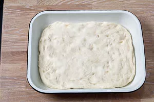 Focaccia-Teig in die Auflaufform legen