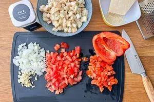 Für die Auberginenfüllung Gemüse schneiden und Parmesan reiben