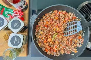 Rinderhackfleisch, Gemüse und Gewürze in einer Pfanne anbraten
