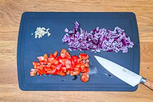 Rote Paprika, Zwiebel und Knoblauch würfeln