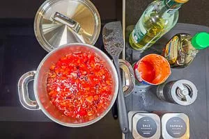 Gemüsezutaten, Essig, Sirup und Gewürze in einem Topf köcheln lassen