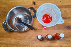 Ketchup mit einem Trichter in Behälter füllen