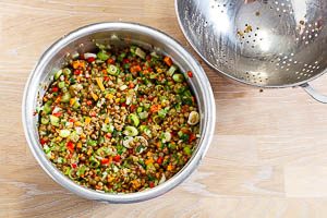 Linsen und Gemüse in einer Schüssel vermengen