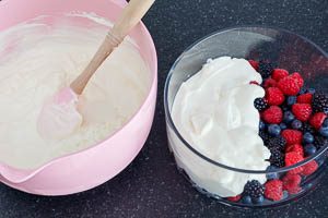Beeren und Quark-Creme abwechselnd in eine Schüssel oder Gläser schichten