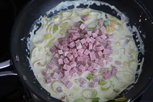 Schinkenwürfel in die Soße geben.