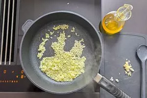 Knoblauch, Zwiebeln und Öl in einer Pfanne erhitzen