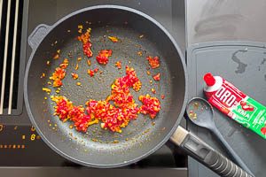 Tomatenmark in die PFanne hinzugeben