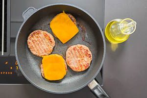 Pattys anbraten, Käse auf die Pattys legen und zum Schmelzen bringen