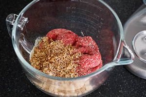 Rinderhackfleisch mit Salz und Pfeffer zu den Semmelbröseln geben