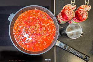 Gebratenes Hackfleisch mit Tomatensoße ablöschen