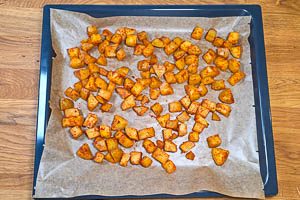 Kartoffelwürfel auf ein Backblech mit Backpapier verteilen