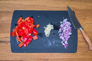 Schalotten, Knoblauch und rote Paprika vorbereiten und kleinschneiden