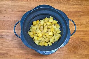 Gekochte Kartoffeln durch ein Sieb abgießen