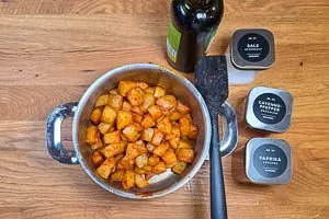 Kartoffelwürfel mit Olivenöl und Gewürzen vermischen