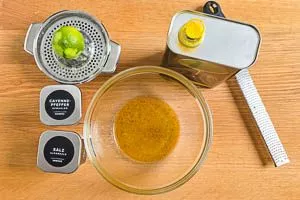 Limette abwaschen, Schale abreiben, Saft auspressen und mit Olivenöl, Salz und Cayennepfeffer vermischen.