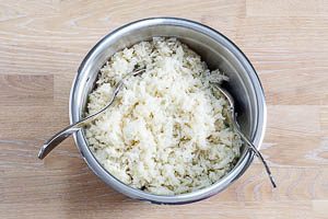 Gib den Reis auf das Gemüse, verrühre den Salat aber noch nicht.