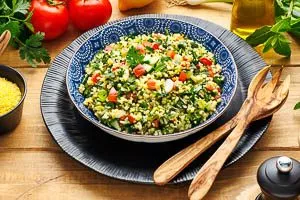 Das gewürfelte Gemüse, die Kräuter und das Dressing mit dem Bulgur vermengen und in einer Schüssel servieren