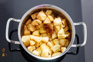Apfelstücke zum Karamell geben und mit Apfelsaft ablöschen