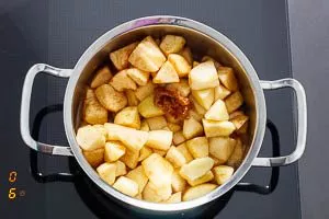Apfelstücke zum Karamell geben und mit Apfelsaft ablöschen