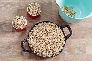 Streusel auf die Apfelspalten geben