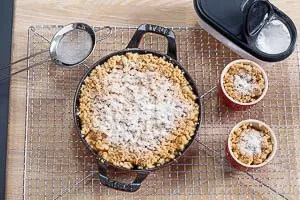 Puderzucker auf den fertigen Apple Crumble steuen.