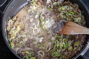 Mit Gemüsebrühe und Frischkäse ablöschen.