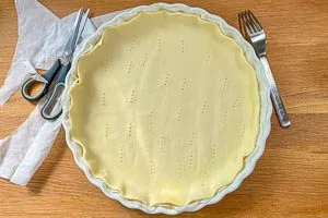 Den Quicheteig in die Form legen.