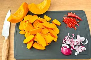 Kürbis, Zwiebel und Peperoni klein schneiden.