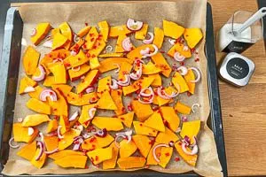 Auf das Backblech mit dem anderen Gemüse verteilen und mit Öl beträufeln