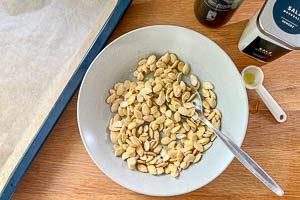 Kürbiskerne mit Olivenöl und Salz vermengen