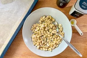 Kürbiskerne mit Olivenöl und Salz vermengen