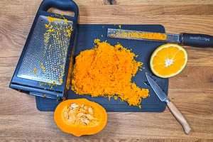 Kürbis klein raspeln, Orangenzeste mit einer Reibe abreiben