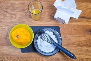 Aus Orangensaft und Puderzucker einen Guss herstellen.