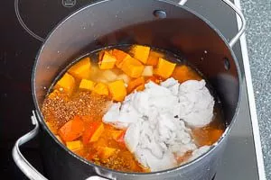 Kürbis und Kartoffeln mit Kokosmilch, Orangensaft, Gemüsebrühe, Chiliflocken und Currypulver aufkochen