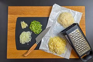 Zwiebeln, Knoblauch und Sellerie waschen und kleinschneiden sowie Käse reiben