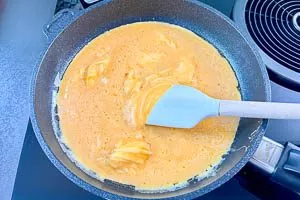 Butter in der Pfanne zerlassen und Eier dazugeben. Dann mit dem Pfannenwender über den Pfannenboden schaben.