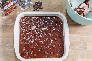 Brownie-Rührteig in die Backform füllen und Chocolate Chunks drüberstreuen