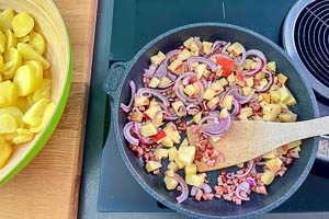 Kartoffeln, Speck und die weiteren Zutaten in der Pfanne anbraten