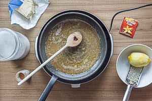 Zitrone waschen und Schale abreiben, Butter schmelzen und die Zutaten für die Füllung zugeben.