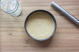 Boden für den gedeckten Apfelkuchen ausrollen und in die Form drücken.