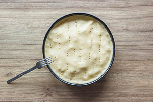 Deckel auf den Kuchen geben und mit der Gabel einstechen.