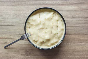 Deckel auf den Kuchen geben und mit der Gabel einstechen.