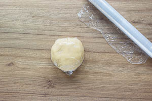 Den Teig zu einer Kugel formen und in Frischhaltefolie wickeln.