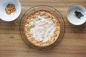 Zuckerguss auf dem Kuchen verteilen und Mandeln darauf verteilen.