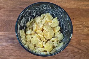 Kartoffelscheiben mit Mayo-Dressing vermengen