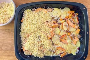 Gemüse in der Auflaufform verteilen und mit frisch geriebenem Käse bestreuen