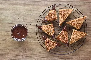 Die Nussecken mit den Ecken in Schokolade tauchen.