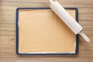 Teig auf dem Backblech ausrollen.