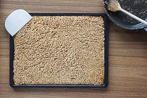 Die Nussmasse auf den Mürbteig streichen.