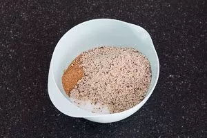 Wei&szlig;en Zucker, braunen Zucker und gemahlene Haseln&uuml;sse vermengen